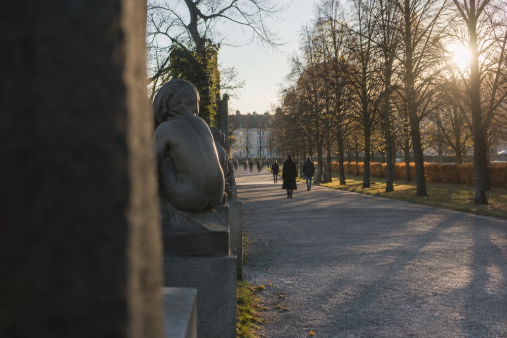 Sculure park pathway lined with stone figures in daylight