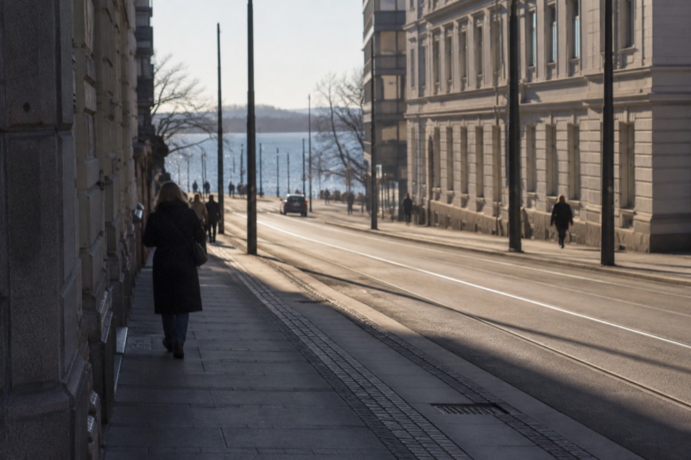 A tram and a metro sign together at a central Oslo transport hub