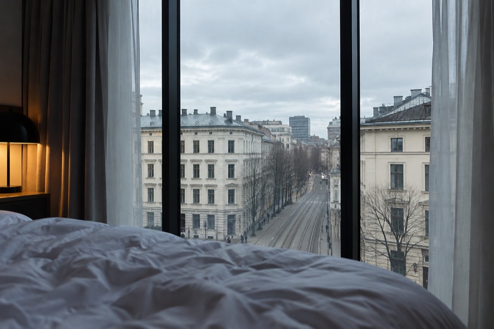 Hotel room with large windows overlooking a Scandinavian city street