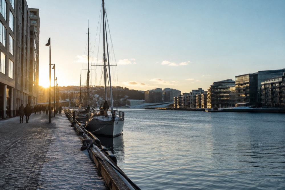 Harbor waterfront with moored boats and modern buildings along a Scandinavian city shoreline