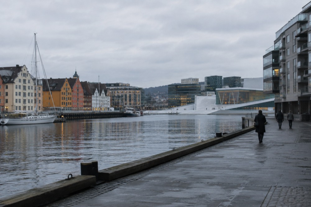 Two Nordic city waterfronts side by side, one with colorful facades and one with modern glass architecture