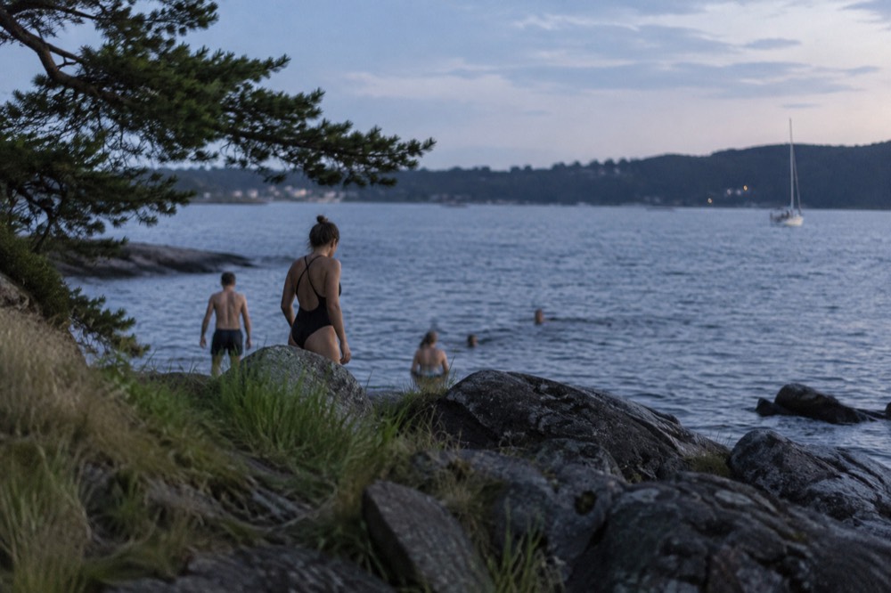 People swimming from a rocky beach on an Oslofjord island in summer