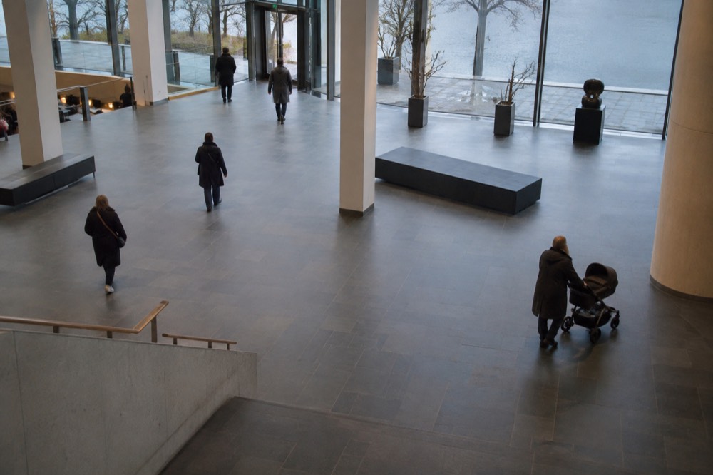 A museum foyer with wide open floor space and a stroller parked inside
