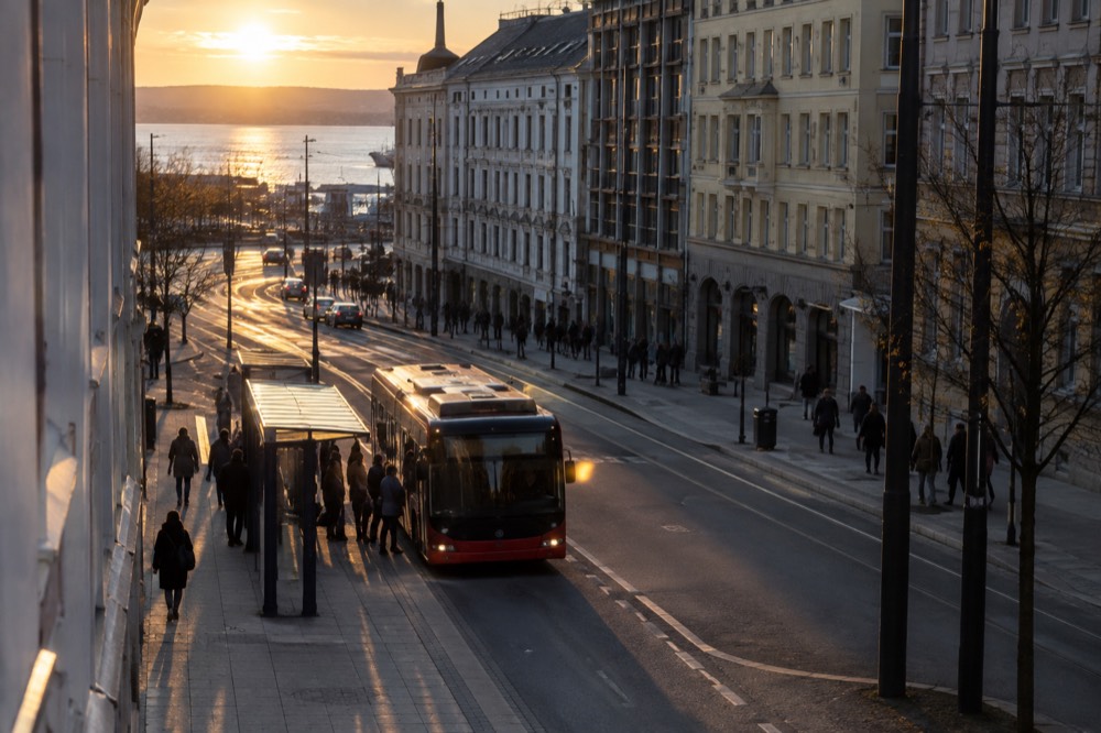 A bus stopping at a shelter marked with a route sign in an Oslo street