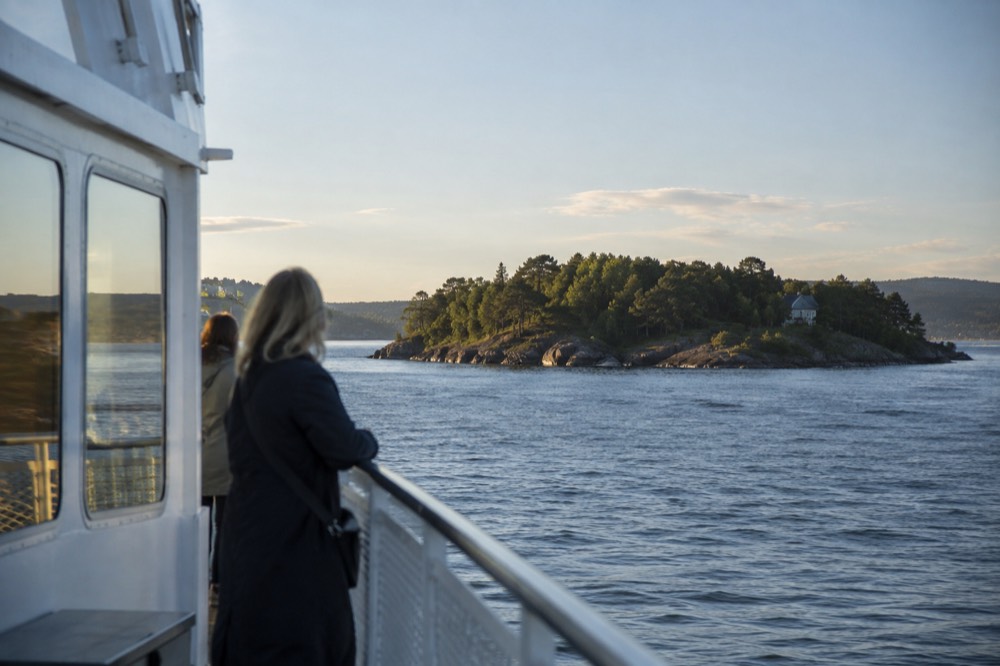 Ferry approaching a small wooded island in the Oslofjord