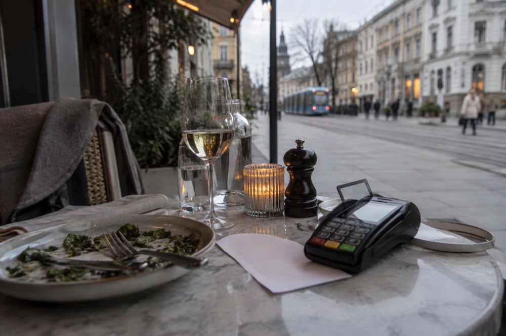 A dinner bill and card terminal on a restaurant table in Oslo