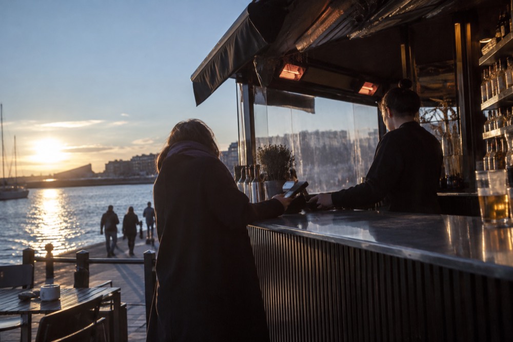 A waterfront bar in Oslo with customers paying by card