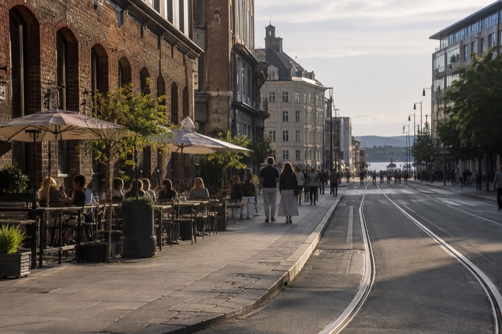 Street corner with outdoor cafe tables and brick warehouse buildings