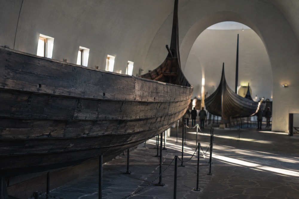 Wooden Viking-era and polar expedition ships inside a museum hall on Bygdøy