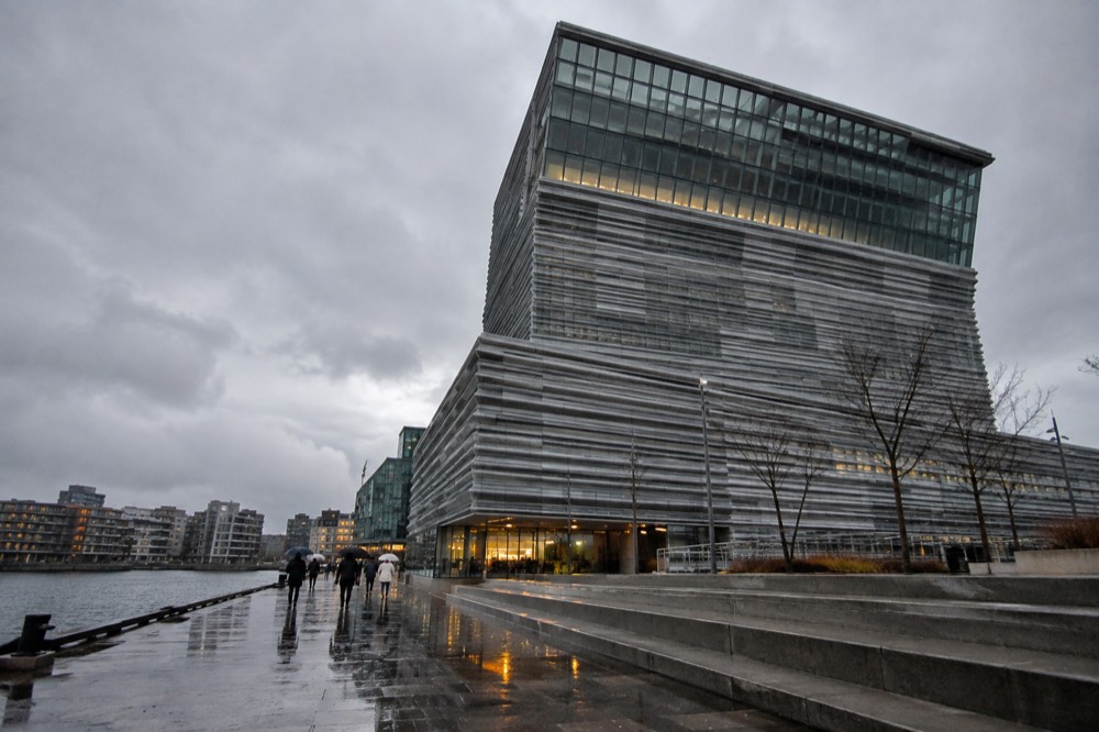 Rainy Oslo street with reflections on wet pavement and the MUNCH museum facade