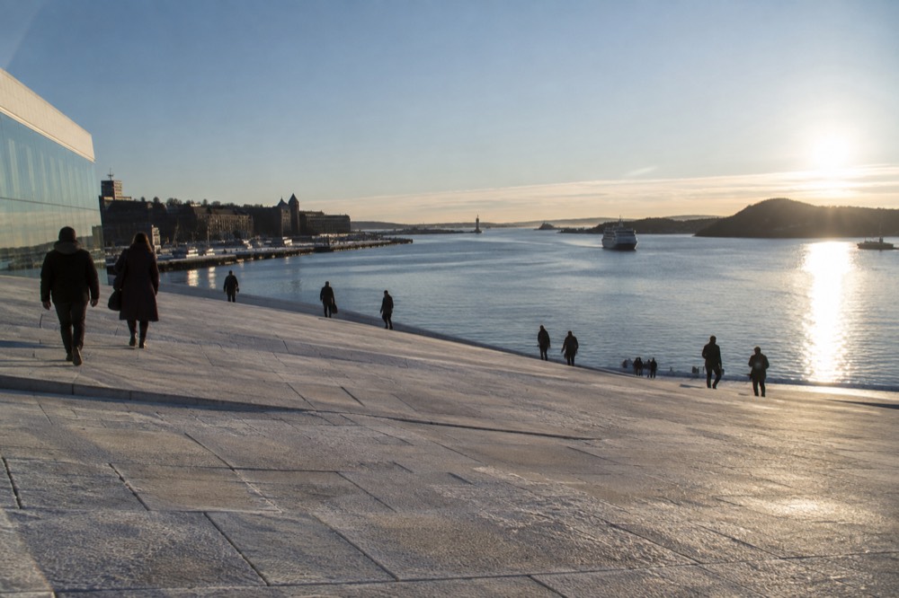 Oslo Opera House roof sloping down toward the Oslofjord on a clear morning