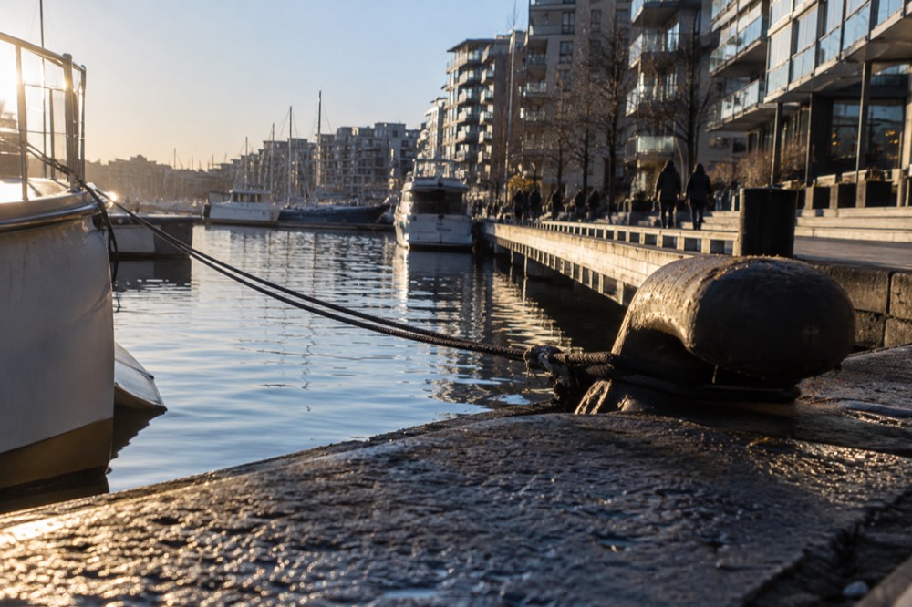 Aker Brygge waterfront promenade with moored boats and apartment buildings