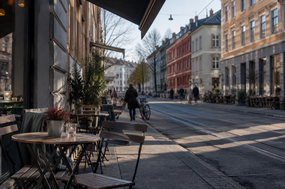 Grünerløkka street with colorful facades, bicycles and café tables