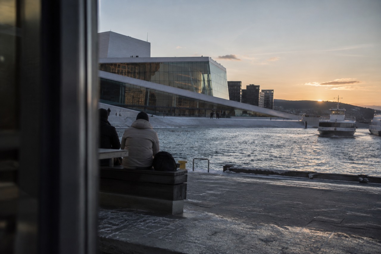 Oslo waterfront with the opera house and fjord boats in soft evening light