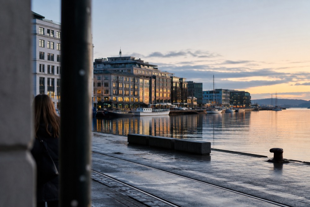 Oslo waterfront buildings reflected in still fjord water at dusk