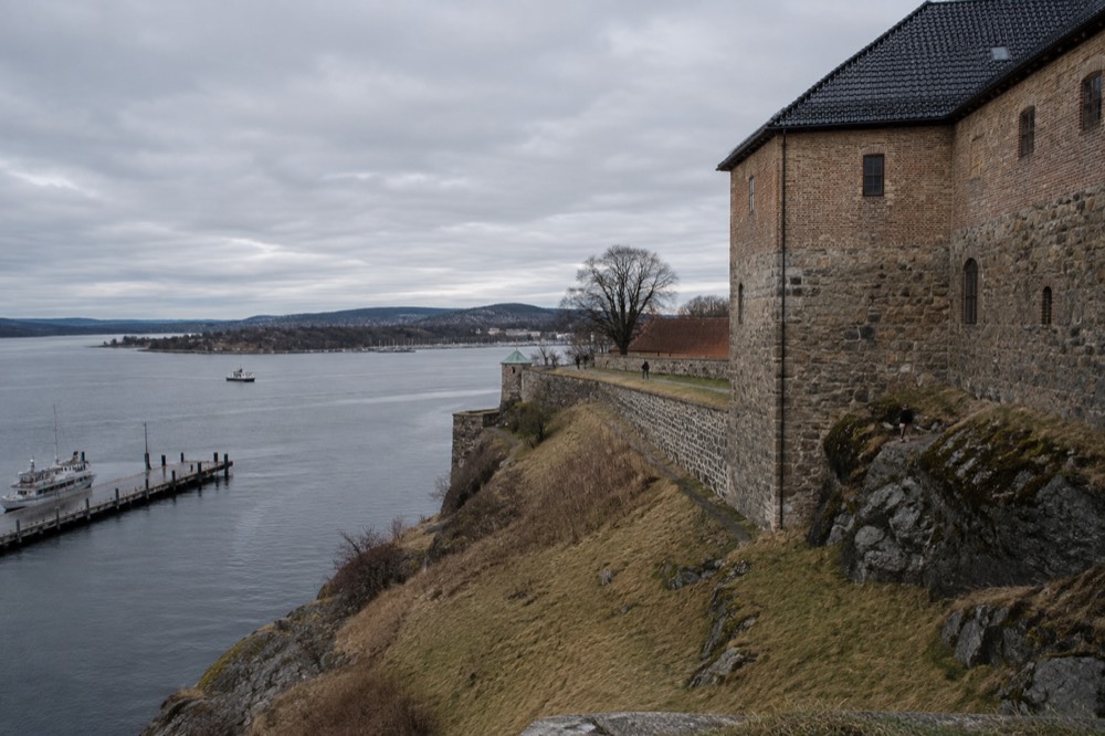 Akershus Fortress stone walls above the fjord under a cloudy sky