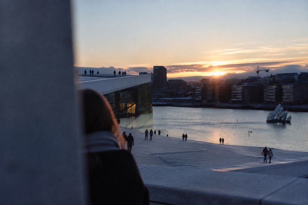 Oslo city skyline at dusk with the opera house roof and fjord in evening light