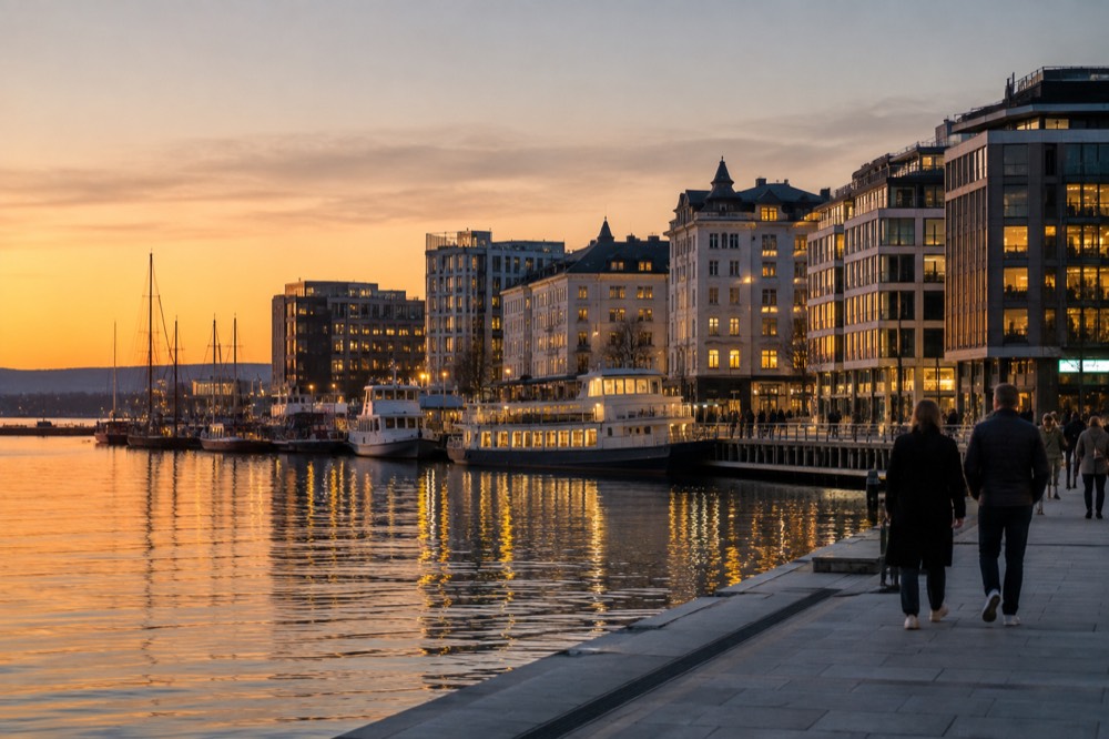 Oslo waterfront at night with lit buildings reflected in the fjord
