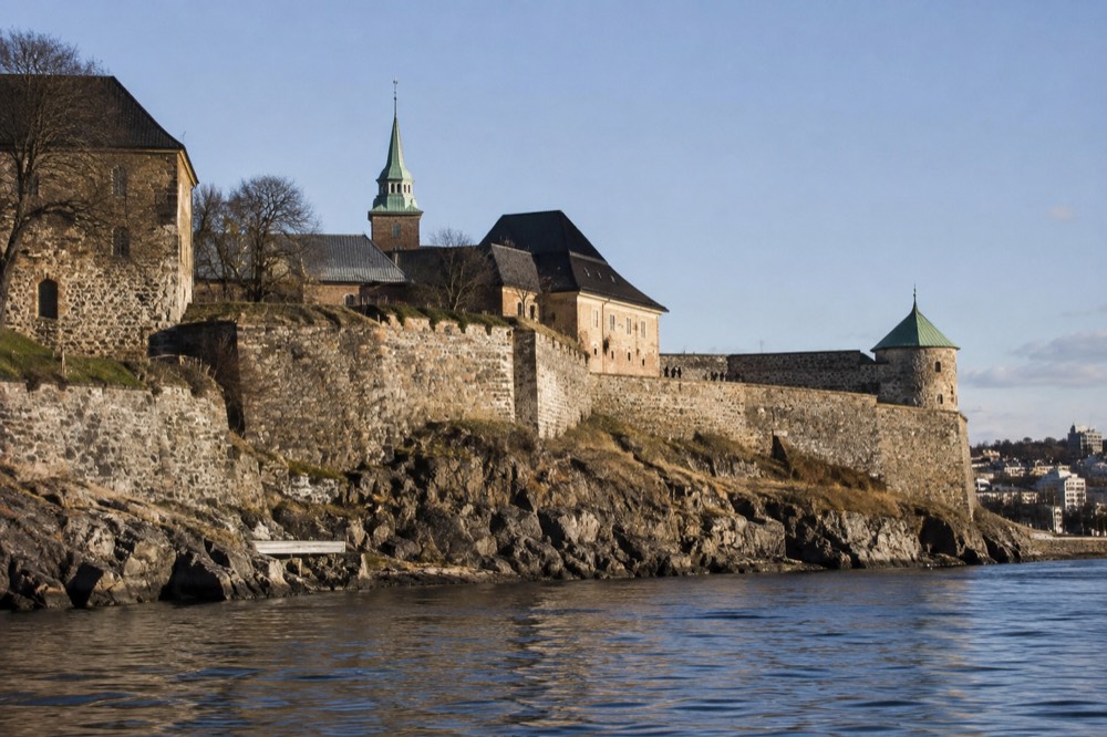 Stone walls of Akershus Fortress seen from the water on a clear day