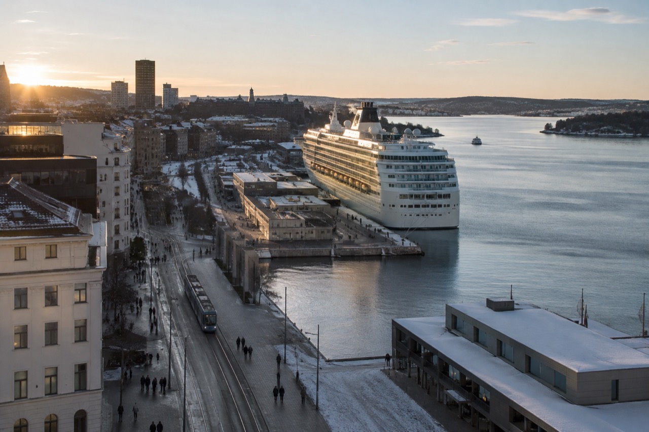 Cruise ship moored at a Oslo waterfront pier with the city skyline behind