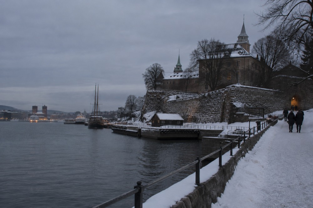 Akershus fortress and harbor in Oslo under snow and early darkness