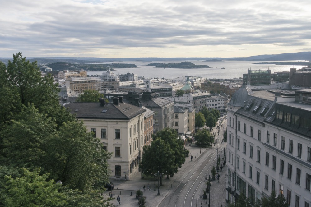 A viewpoint above Oslo with the city and fjord stretching to the horizon in summer light