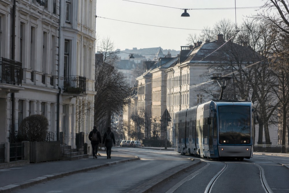 A tram moving along a street lined with old apartment buildings