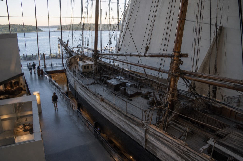 A wooden expedition ship displayed inside a museum hall