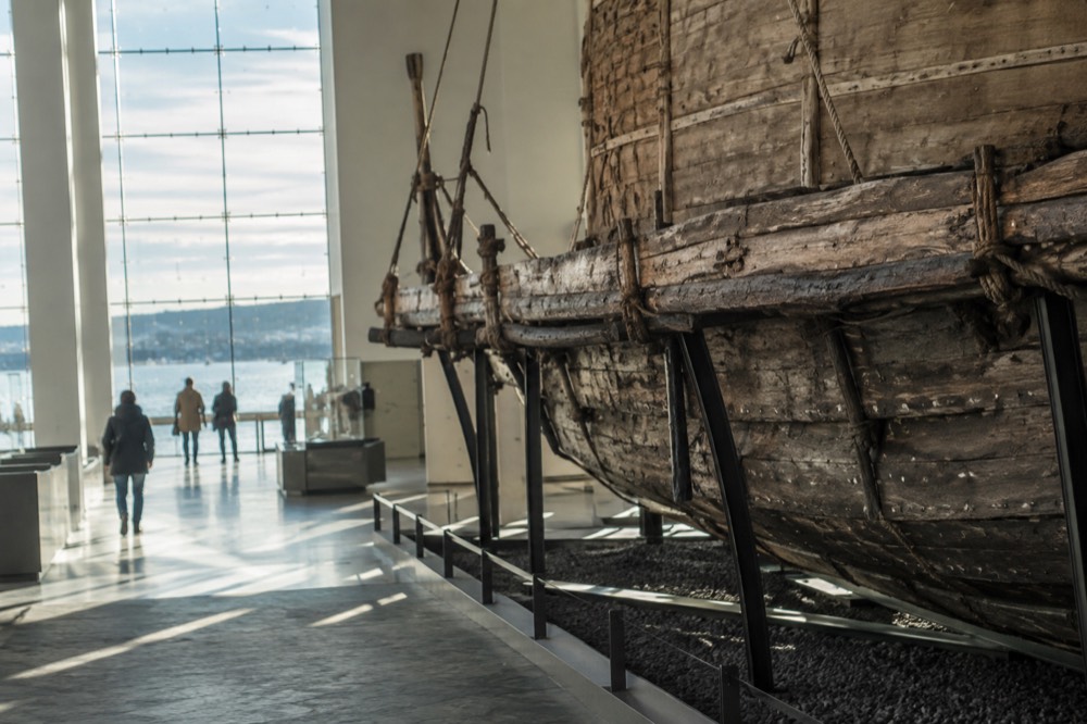 Wooden raft hull displayed inside a bright museum hall
