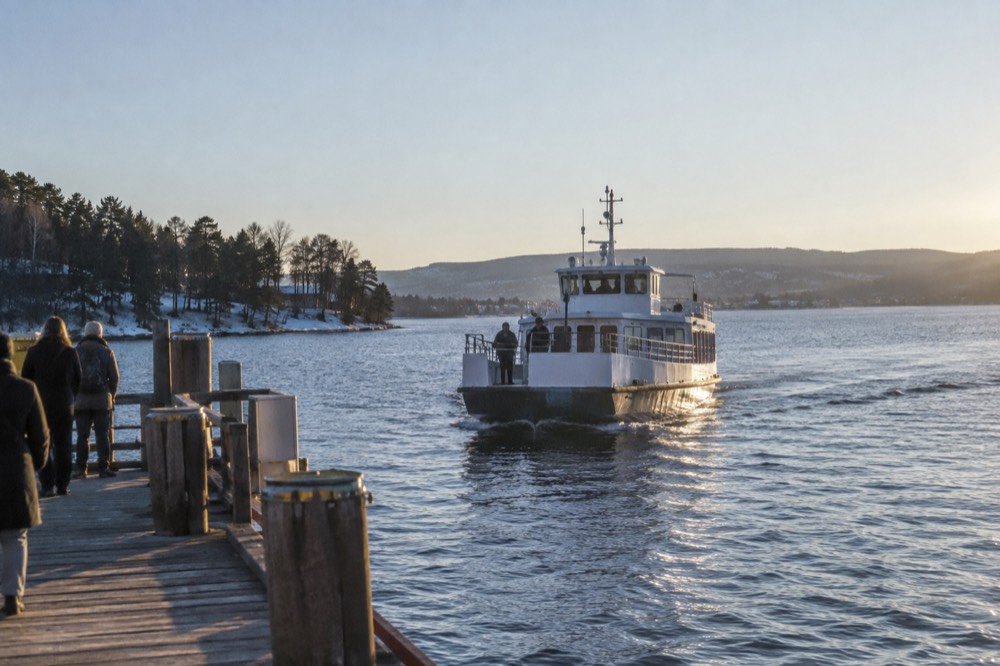 A small passenger ferry approaching a wooden pier on the Bygdøy peninsula