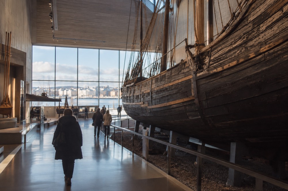 Interior gallery of a Oslo museum with tall wooden ship hull on display